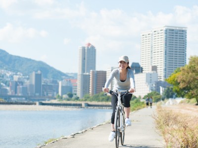 河川敷を自転車で走る日本人女性