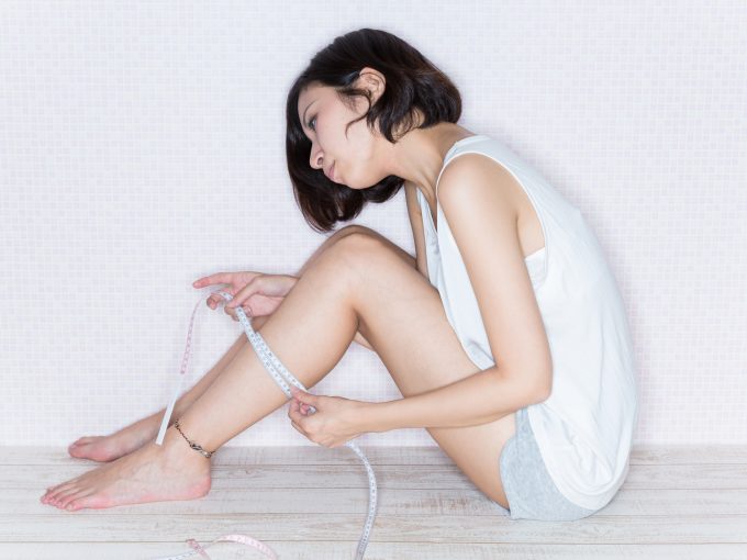 ふくらはぎを測る女性