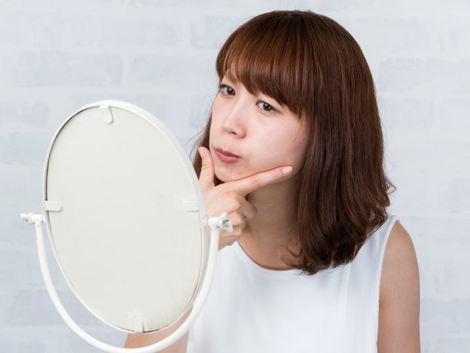 顔のエラを気にする女性