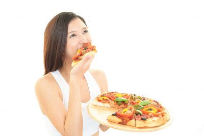 過食のイメージ：ピザ食べる女性