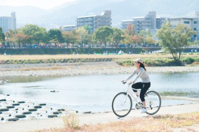 河川敷で自転車に乗っている日本人女性