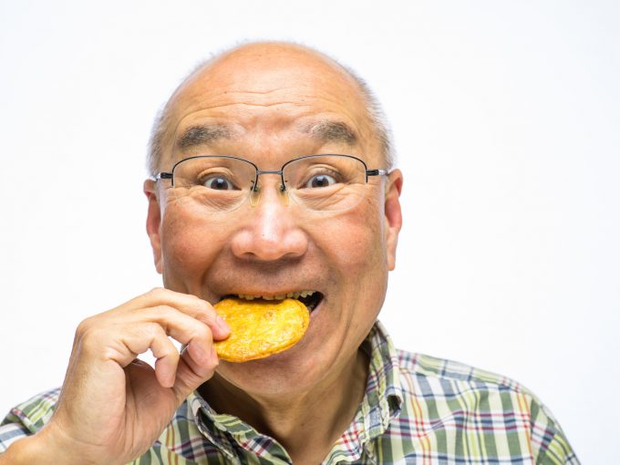 固い食べ物（煎餅を食べるシニア）