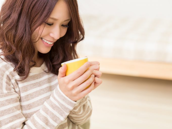 部屋でセンナ茶を飲む女性