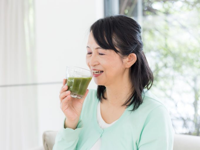 青汁を飲む中年女性