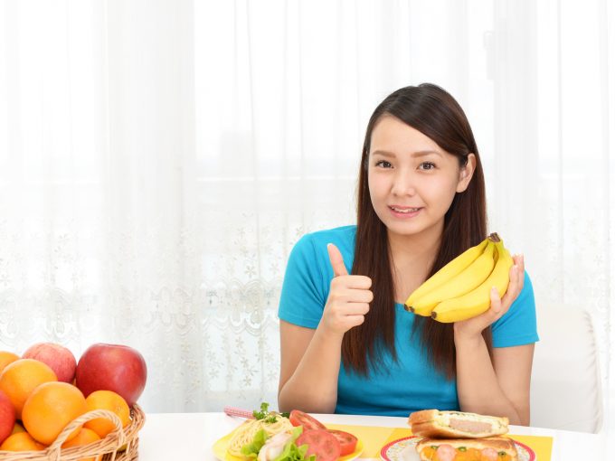 朝食にバナナを食べる女性