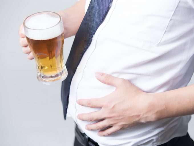 内臓脂肪が多いビールを持つサラリーマン