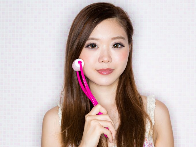 美顔ローラーを持つ女性