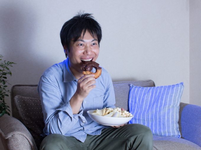 ドーナツを食べる夜遅くに食べる男性