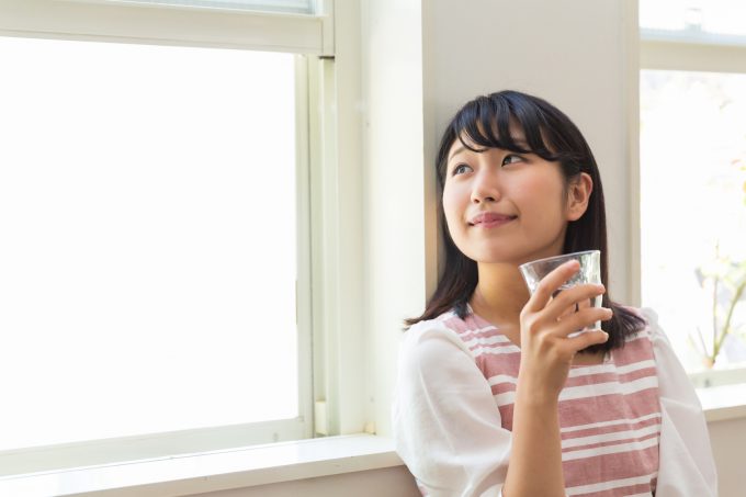 部屋で水を飲む女性