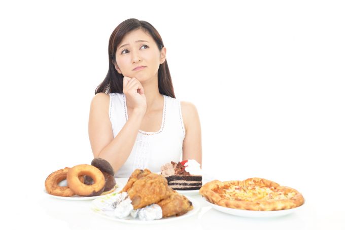 暴飲暴食を我慢する女性