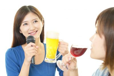 お酒を楽しみながら歌う女性