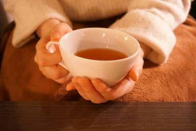 温かい紅茶を持つ女性の手